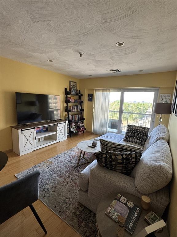 133 Commander Shea Blvd Unit 614, Quincy, MA 02171 - living area with wood finished floors and a textured ceiling