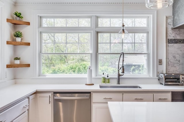 72 Oliver Snow Rd, Harwich, MA 02646 - kitchen with stainless steel dishwasher, a sink, white cabinets, light countertops, and hanging light fixtures