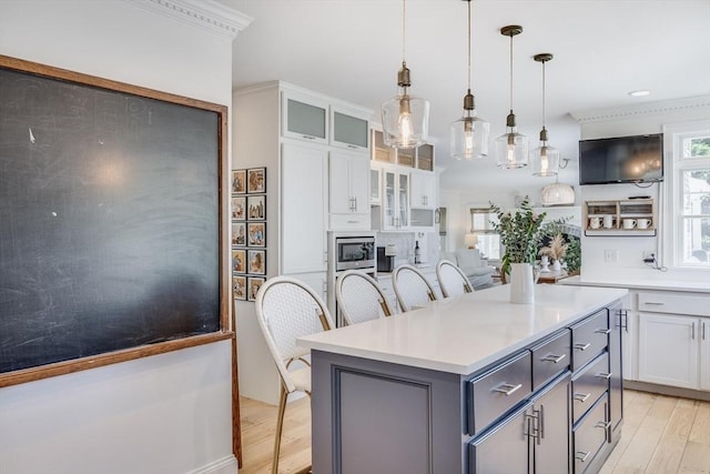 72 Oliver Snow Rd, Harwich, MA 02646 - kitchen with light wood finished floors, white cabinetry, a center island, gray cabinets, and light countertops