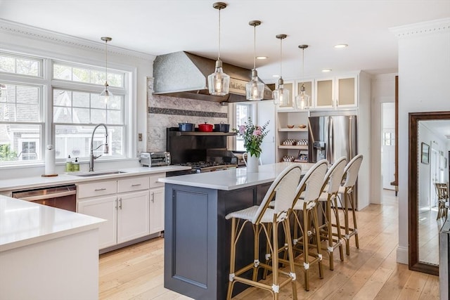 72 Oliver Snow Rd, Harwich, MA 02646 - kitchen with a sink, stainless steel appliances, light wood-style flooring, white cabinets, and a center island