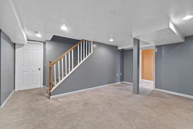 finished basement featuring carpet flooring, stairway, and baseboards