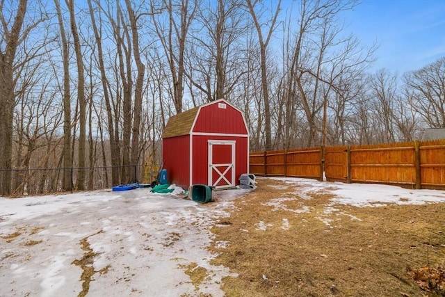 snow covered structure featuring a barn, fence, and an outdoor structure