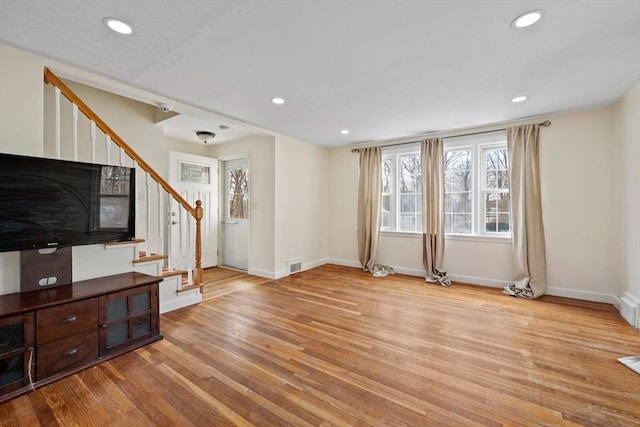 living area featuring baseboards, visible vents, wood finished floors, stairs, and recessed lighting