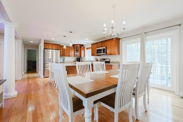 dining room featuring recessed lighting, an inviting chandelier, a wealth of natural light, and light wood-style floors