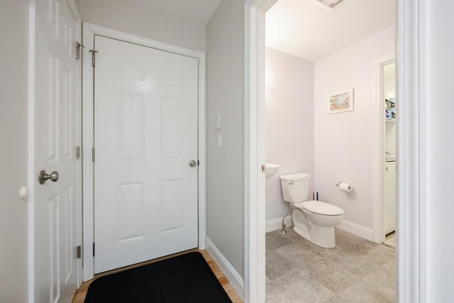 bathroom with toilet and baseboards