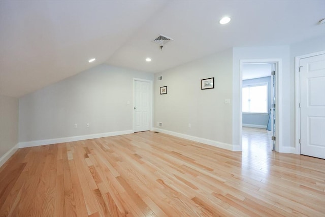 additional living space with recessed lighting, light wood finished floors, vaulted ceiling, and baseboards