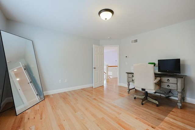 office area with baseboards, visible vents, and wood finished floors
