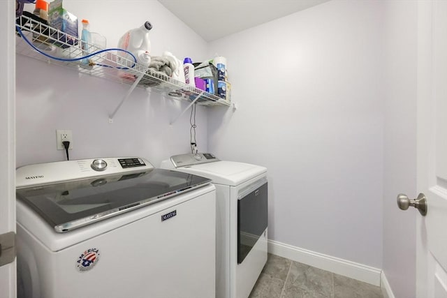 laundry room featuring separate washer and dryer, laundry area, and baseboards