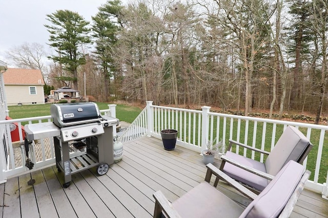 wooden terrace featuring area for grilling and a yard