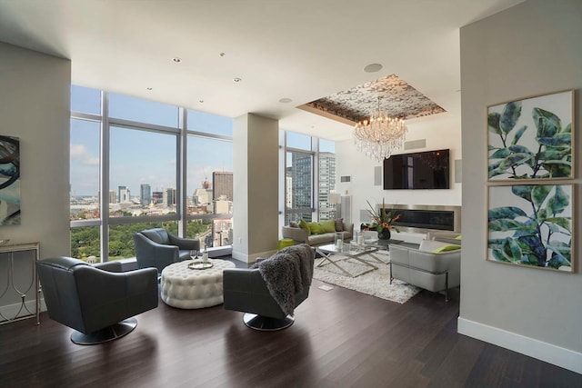 living room with a chandelier, expansive windows, and dark hardwood / wood-style flooring