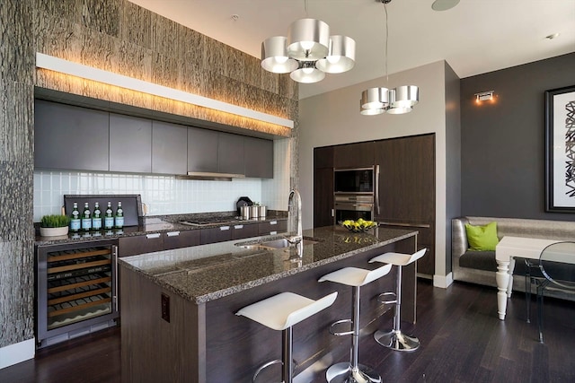 kitchen featuring dark brown cabinets, beverage cooler, a notable chandelier, appliances with stainless steel finishes, and sink