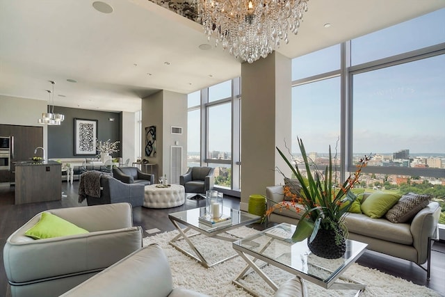 living room with wood-type flooring, a chandelier, sink, and a wall of windows