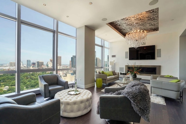 living room featuring floor to ceiling windows, a wealth of natural light, dark hardwood / wood-style flooring, and a notable chandelier