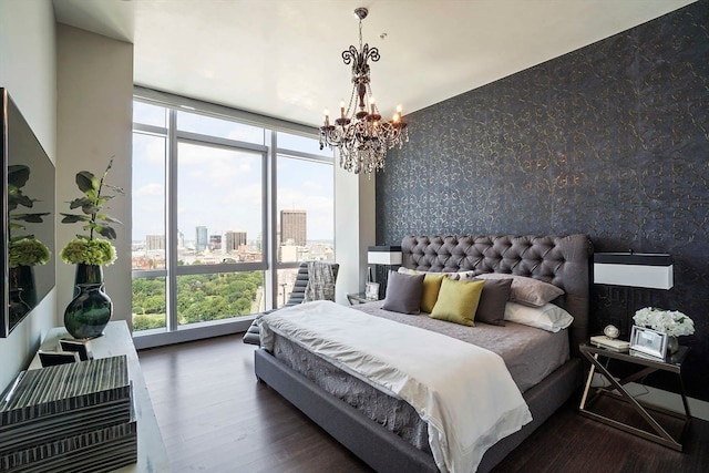 bedroom with a chandelier, expansive windows, and dark hardwood / wood-style flooring