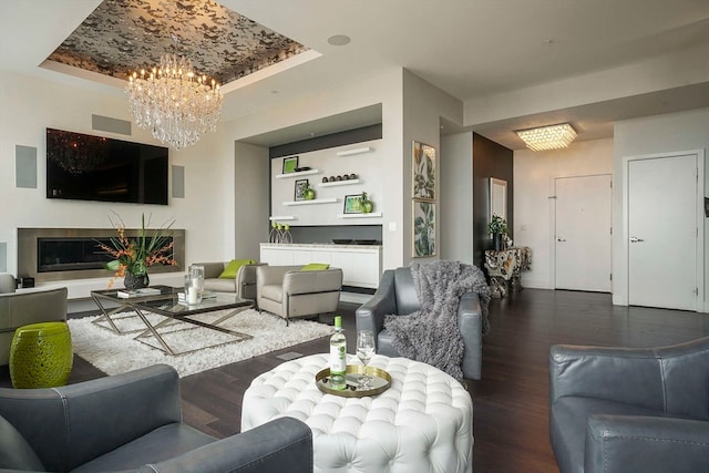 living room featuring a tray ceiling, a notable chandelier, and hardwood / wood-style flooring