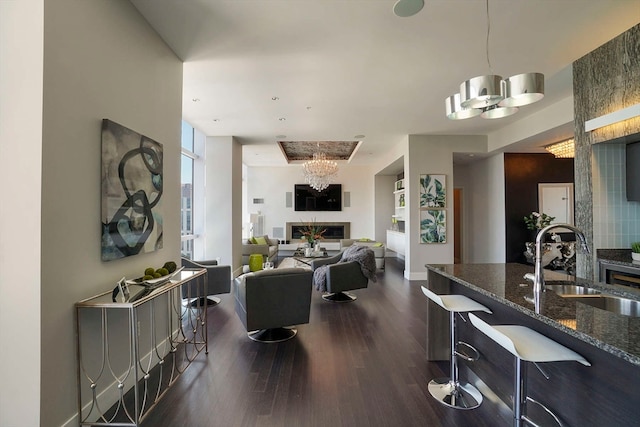 living room with dark wood-type flooring, sink, and a chandelier