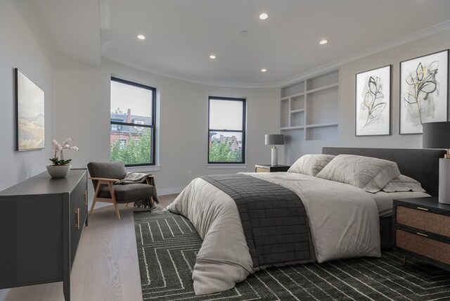 bedroom with dark hardwood / wood-style flooring and ornamental molding