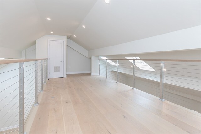 additional living space with light wood-type flooring and lofted ceiling