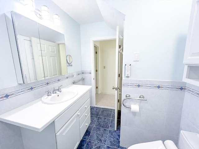 23 Hobart Ln Unit 23, Rockland, MA 02370 - bathroom with toilet, tile patterned floors, tile walls, vanity, and a wainscoted wall