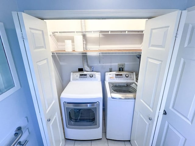 23 Hobart Ln Unit 23, Rockland, MA 02370 - clothes washing area with washing machine and clothes dryer and light tile patterned floors