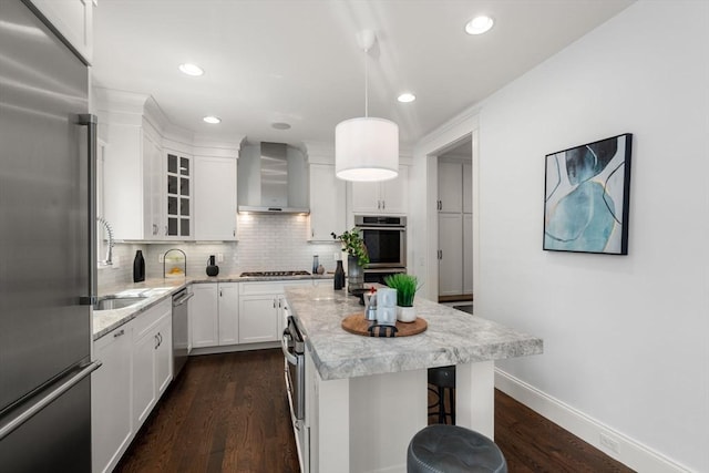 23 Troy Ln Unit 23, Newton, MA 02468 - kitchen featuring appliances with stainless steel finishes, wall chimney range hood, white cabinetry, backsplash, and a kitchen island