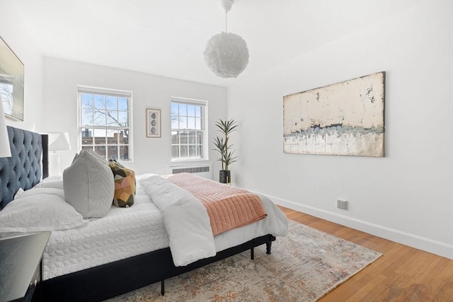 bedroom with baseboards and wood finished floors