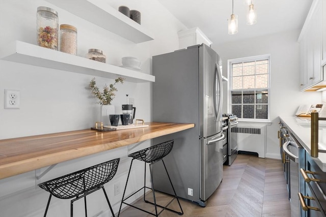 kitchen with stainless steel appliances, a breakfast bar, wood counters, white cabinets, and open shelves