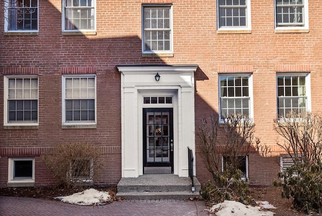 doorway to property featuring brick siding