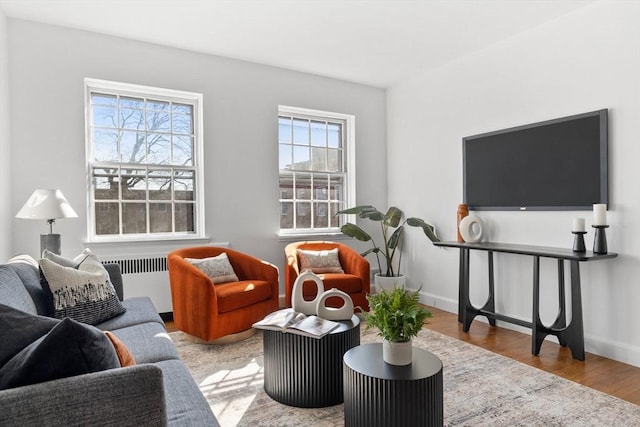 sitting room featuring radiator heating unit, wood finished floors, and baseboards