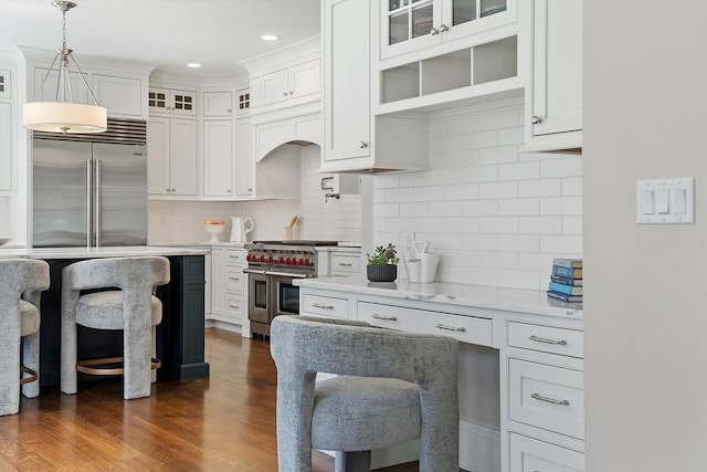 kitchen featuring tasteful backsplash, high quality appliances, and white cabinets