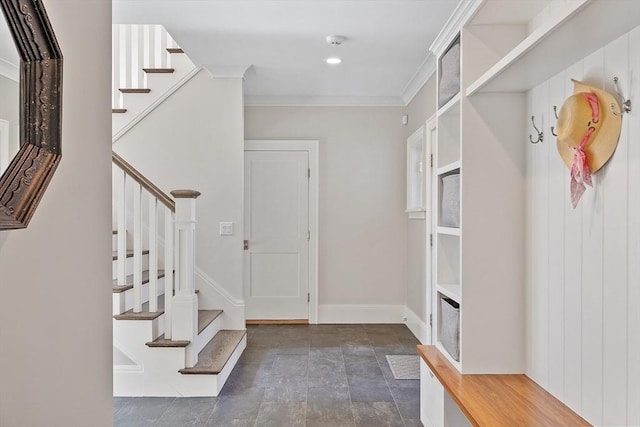 mudroom with crown molding, stone finish floor, and baseboards