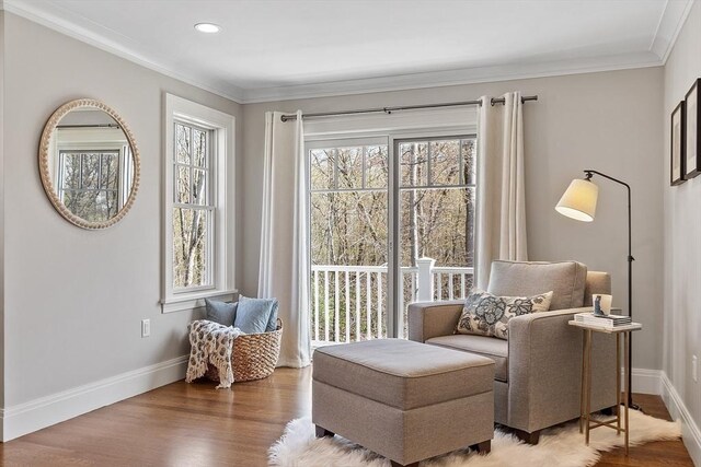 sitting room with baseboards, a wealth of natural light, and wood finished floors