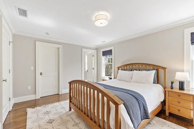 bedroom featuring visible vents, ornamental molding, dark wood finished floors, and baseboards
