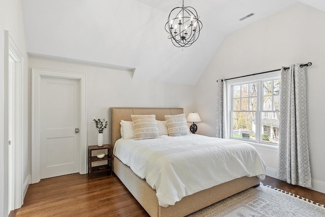 bedroom with visible vents, baseboards, lofted ceiling, and wood finished floors
