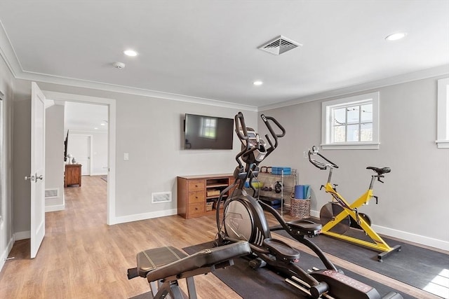 exercise room with crown molding, baseboards, and visible vents
