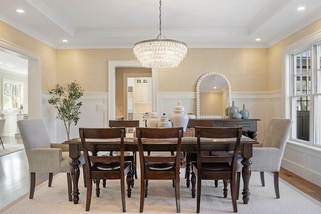 dining space with a chandelier, ornamental molding, a wealth of natural light, and a decorative wall