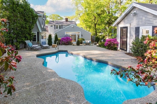 outdoor pool featuring a patio area and an outdoor structure