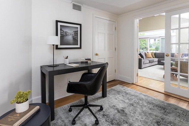 home office with wood finished floors, crown molding, and baseboards
