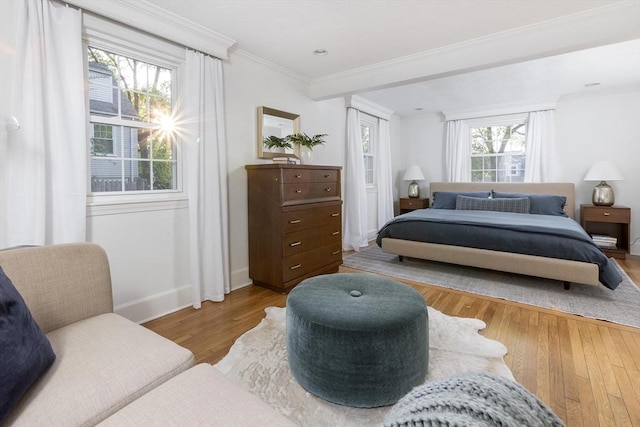 bedroom featuring wood finished floors, ornamental molding, and baseboards
