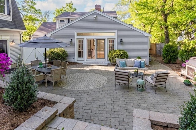 view of patio with fence, an outdoor living space, french doors, and outdoor dining area