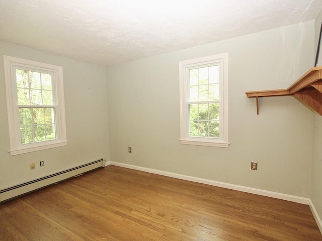 14 Oak Cir, Princeton, MA 01541 - unfurnished room featuring plenty of natural light, wood finished floors, baseboard heating, and a textured ceiling