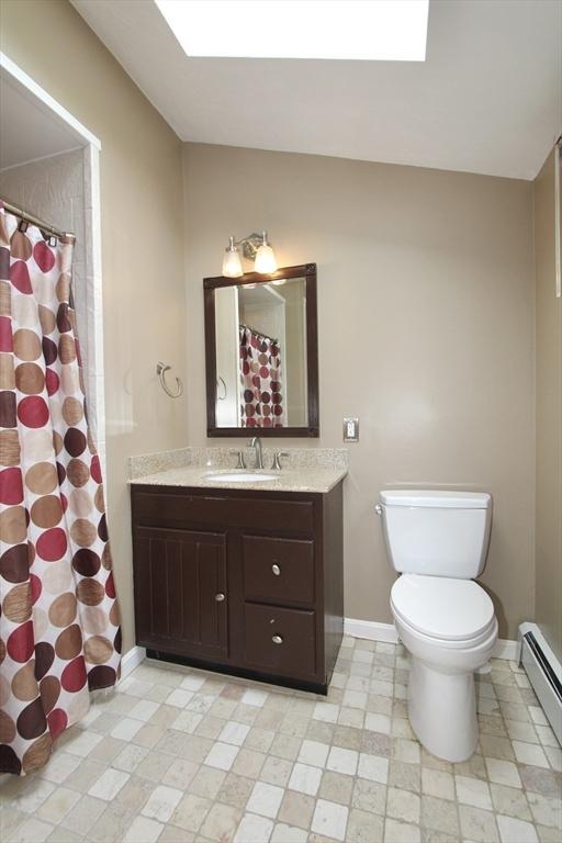 14 Oak Cir, Princeton, MA 01541 - full bathroom featuring baseboard heating, vanity, lofted ceiling, a skylight, and a shower with curtain