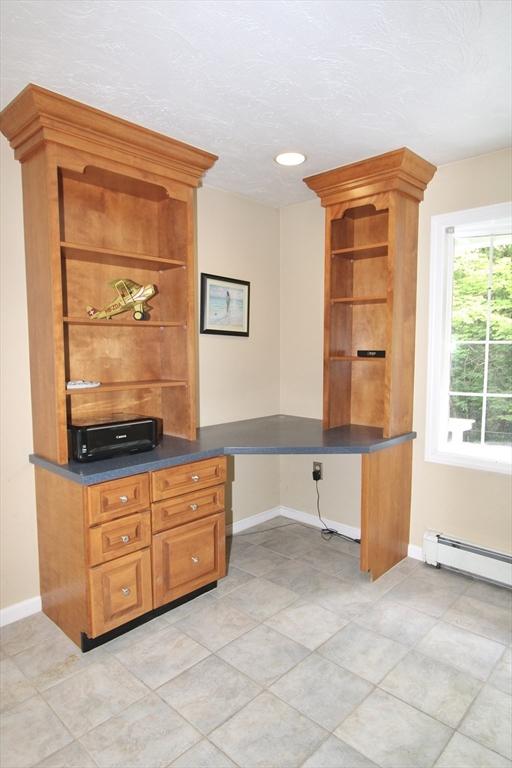 14 Oak Cir, Princeton, MA 01541 - kitchen featuring open shelves, dark countertops, a baseboard heating unit, and brown cabinets