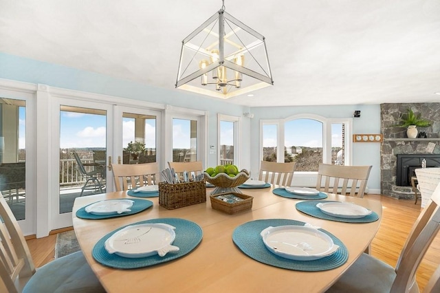 3 Longview Ter, Gloucester, MA 01930 - dining space featuring wood finished floors, a fireplace, a chandelier, and baseboards