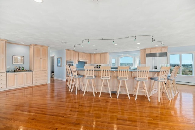 3 Longview Ter, Gloucester, MA 01930 - kitchen with light brown cabinets, appliances with stainless steel finishes, light wood-style floors, a kitchen bar, and under cabinet range hood