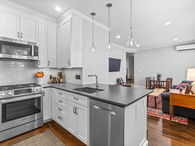 9 Sedgwick St Unit 1, Boston, MA 02130 - kitchen featuring stainless steel appliances, a peninsula, dark countertops, dark wood-style flooring, and decorative backsplash