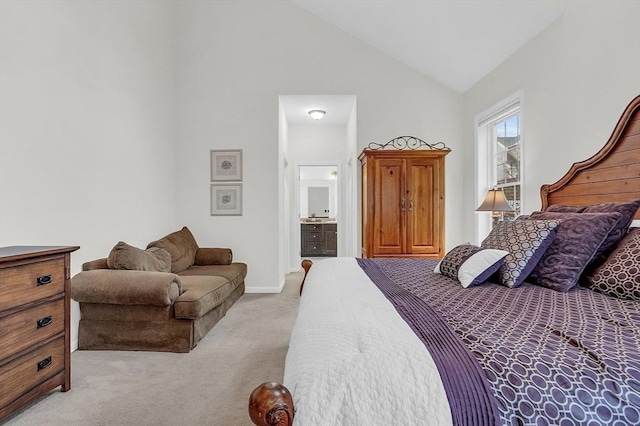 bedroom with ensuite bathroom, high vaulted ceiling, and light colored carpet