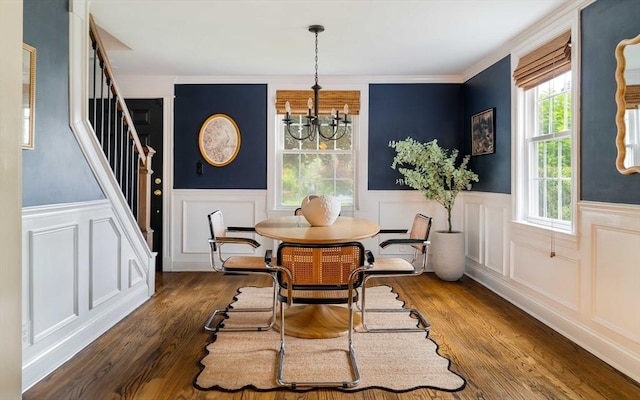 16 Hart Pl, Woburn, MA 01801 - dining space with a chandelier, stairs, a decorative wall, wainscoting, and wood finished floors