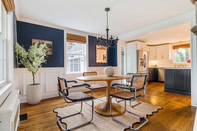 16 Hart Pl, Woburn, MA 01801 - dining room featuring crown molding, wood finished floors, healthy amount of natural light, wainscoting, and a chandelier