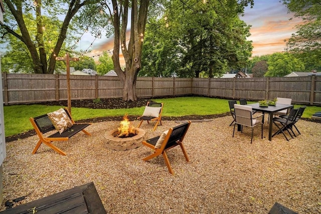 16 Hart Pl, Woburn, MA 01801 - yard at dusk with an outdoor fire pit and a fenced backyard